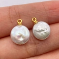 Baroque button-shaped natural freshwater pearl pendants with golden rings on hand - Freshwater Pearl