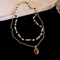 Detail of a gold-plated double-layer necklace with pearl beads and a brown gemstone pendant - Double Layer Maillard Beaded Gold Chain (WN074)