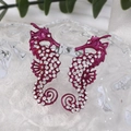 Macro shot of purple beaded seahorse earrings with crystal rhinestones on glass - Purple Seahorse Rhinestone Earrings