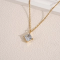 Elegant gold chain necklace featuring a square clear zircon pendant on a textured surface - White