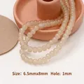 Vista macro di perle crema traslucide 6,5x8mm per la creazione di gioielli fai da te - Perline tonde piatte Dundun (20 pezzi)