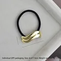 Macro detail of wave-shaped golden alloy hair tie with dimensions 4cm by 1.5cm - Gold Flat Double Wave