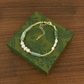 Dettaglio macro di collana in pietra verde e perle su un portagioie in stile vintage - Braccialetto di Perle d'Acqua Dolce Stile Bambù