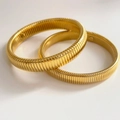Detalle de dos brazaletes Tubogas dorados con textura clásica de metal acanalado - 15mm Color Oro