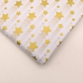 Macro shot of white tissue paper featuring decorative gold star patterns for flower wrapping - Gold Star