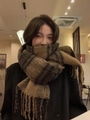 Brown plaid mohair-feel scarf with tassels worn by model in a cozy setting - Dark Maillard Plaid