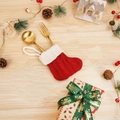 Mini chaussette de Noël rouge tricotée avec couverts dorés sur fond de fête - Mini chaussette tricotée rouge