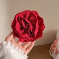 Detailed view of handcrafted red fabric rose hair claw with intricate embroidery texture - Red