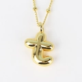 Detail of gold bubble letter t pendant with beaded chain on white background - Letter T