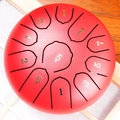 Red steel tongue drum featuring gold numbered notes on a rustic wooden texture background - Cinnabar Red - Panda (6 Inch 11 Notes)