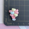 Détails de breloques ballons cœur en résine colorée avec échelle de taille sur tapis - Ballon Rose Cuir