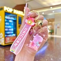 Detail of pink unicorn liquid glitter keychain with silicone strap and golden bell charm - Luminous Donut Flat Candy