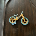 Miniature orange and blue toy balance bike keychain ornament on dark wood tray - Medium / Yellow