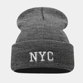 Détail du bonnet en maille grise avec broderie NYC blanche et texture côtelée - Gris chiné foncé
