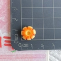 Macro detail of a 1.5cm orange gradient resin flower charm on a metric scale grid - Seven-Petal Flower Sandwich Bread