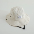 Détail du chapeau beige pour enfant avec écusson Go violet et boutons-pression latéraux - 52cm / Blanc Cassé