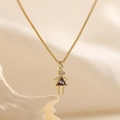 Macro detail of gold-plated girl pendant with purple and clear zircon stones on box chain - June Dark Purple