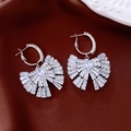 Vista detallada de los pendientes de lazo de plata con circonitas sobre satén marrón - Hebilla de Oreja de Lazo Elegante / 55# Hebilla de Oreja-Plata-Lazo