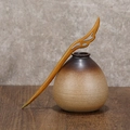 Handcrafted green sandalwood hair pin with hollow carving next to ceramic vase - Green Sandalwood Immortal Feather