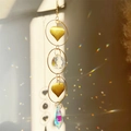 Macro view of crystal suncatcher with gold heart charms and rainbow light reflections - Double Ring Heart Style
