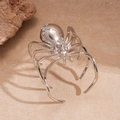 Macro detail of a silver spider bracelet with sparkling rhinestones on textured stone - Silver