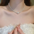 Close-up of a silver bow pearl necklace on collarbone showing elegant texture - Silver Pearl