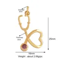 Polished gold stethoscope pendant charm featuring a pink zircon and size measurements - Gold Heart Stethoscope Pink Gem