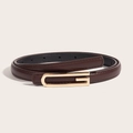 Slim dark brown leather belt for women with a golden G-shaped metal buckle on beige background - Coffee