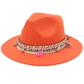 Detail of bohemian orange felt fedora featuring woven band with shells and pink tassels - Orange