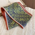 Dettaglio di sciarpa in seta grigia con motivo paisley dorato e bordo stile vintage - Collana Marrone-Verde