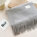 Detail of grey fringed scarf showing soft texture and woven label with Self Service text - Light Gray