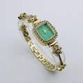 Detail of luxury gold rectangular quartz watch with mint green dial and crystal bracelet - Gold Case Green Dial