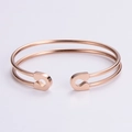 Detalle de brazalete abierto minimalista en oro rosa con diseño de cabeza de alfiler - Oro rosa