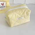 Dettagli del tessuto trapuntato a righe gialle e bianche e dell'etichetta del marchio - Borsa a Sacco a Righe di Caramelle / Giallo