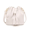 White PU bucket bag featuring elegant double tassels and gold-tone hardware details - White