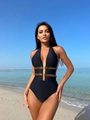 Dettaglio del costume da bagno nero con scollo a V e decoro dorato in vita in spiaggia - XL / Nero