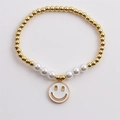 Elegante bracciale con sfere dorate, perle bianche e un ciondolo a forma di sorriso - Bianco