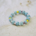 Handcrafted blue ceramic beaded bracelet with colorful floral accent beads on beige paper - 235G Blue Pumpkin