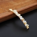 Close-up of gold hairpin with natural white crystal stones on a dark wooden tray - White Moonstone Gold
