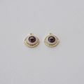 Macro detail of two gold-plated eye charms with brown pupils and white iris details - KC Gold (Brown Eye)