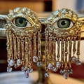 Artistic golden evil eye tassel earrings with green iris and purple pearl accents - Stud Earrings