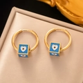 Gold hoop earrings featuring blue cube pendants with white heart and evil eye details - Blue Cube Heart Evil Eye Hoop Earrings Gold
