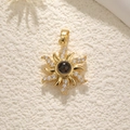 Elegant gold sun-shaped pendant necklace with sparkling zircons and a central dark stone - Gold Sun