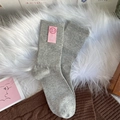Calcetines grises de punto media pierna con etiqueta de cara sonriente rosa en fondo suave - Talla única / Gris