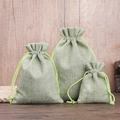 Three light green linen drawstring pouches in small medium large sizes on a wooden table - 7*9cm / Green