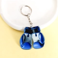 Portachiavi con guantone da boxe in acrilico blu e nero su un piatto decorativo bianco - Guantoni da boxe / Blu
