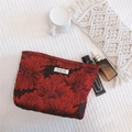 Detailopname van rode bloemen jacquard stof op deze elegante reismake-up tas voor dames - Rood