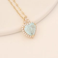 Detailed view of gold heart necklace with ice-cracked light blue stone and crystal halo - Light Blue