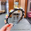 Dettaglio di un cerchietto in plastica nera con girasoli colorati, diametro di 11,3 cm - Fiore a Sei Colori