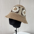 Dettaglio di un cappello di paglia intrecciato a mano con motivi floreali all'uncinetto - Cachi
